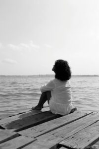 Mujer migrante reflexionando sobre una ruptura amorosa y el duelo migratorio