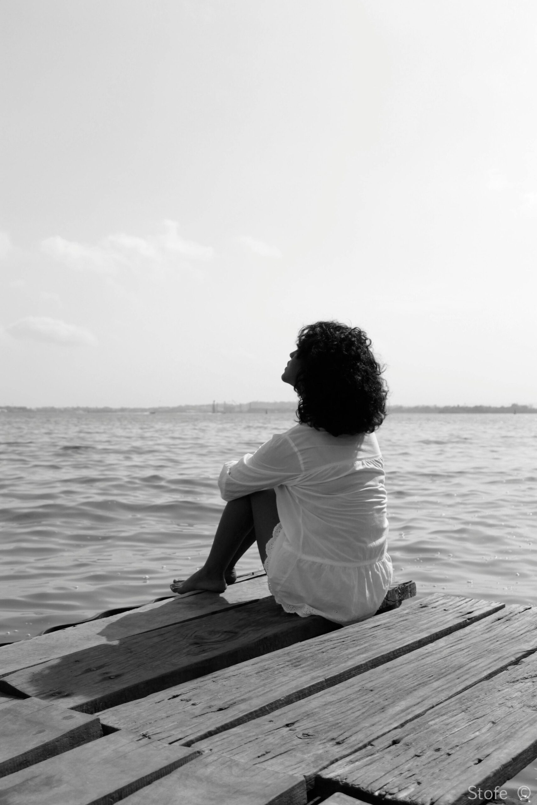 Mujer migrante reflexionando sobre una ruptura amorosa y el duelo migratorio